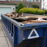 Long,Blue,Dumpster,Full,Of,Wood,And,Other,Debris,In