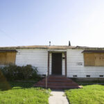 Facade,Of,An,Abandoned,House,With,Boarded,Up,Windows