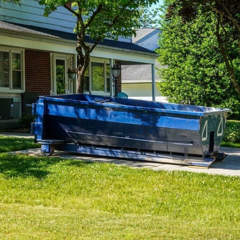 A,Blue,Dumpster,In,The,Driveway,Of,A,House,In