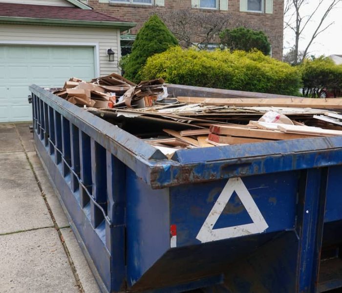 Long,Blue,Dumpster,Full,Of,Wood,And,Other,Debris,In